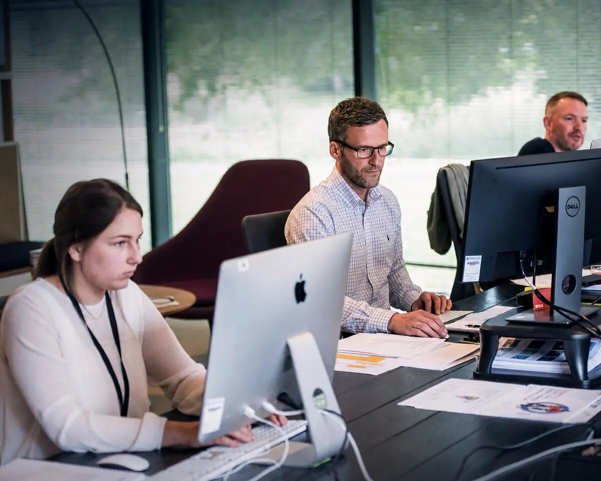 Colleagues working at computers in a modern office
